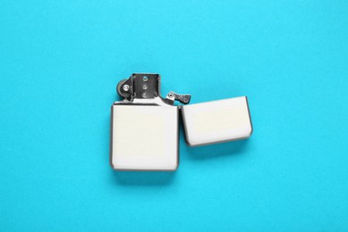 Photo of Gray metallic cigarette lighter on light blue background, top view
