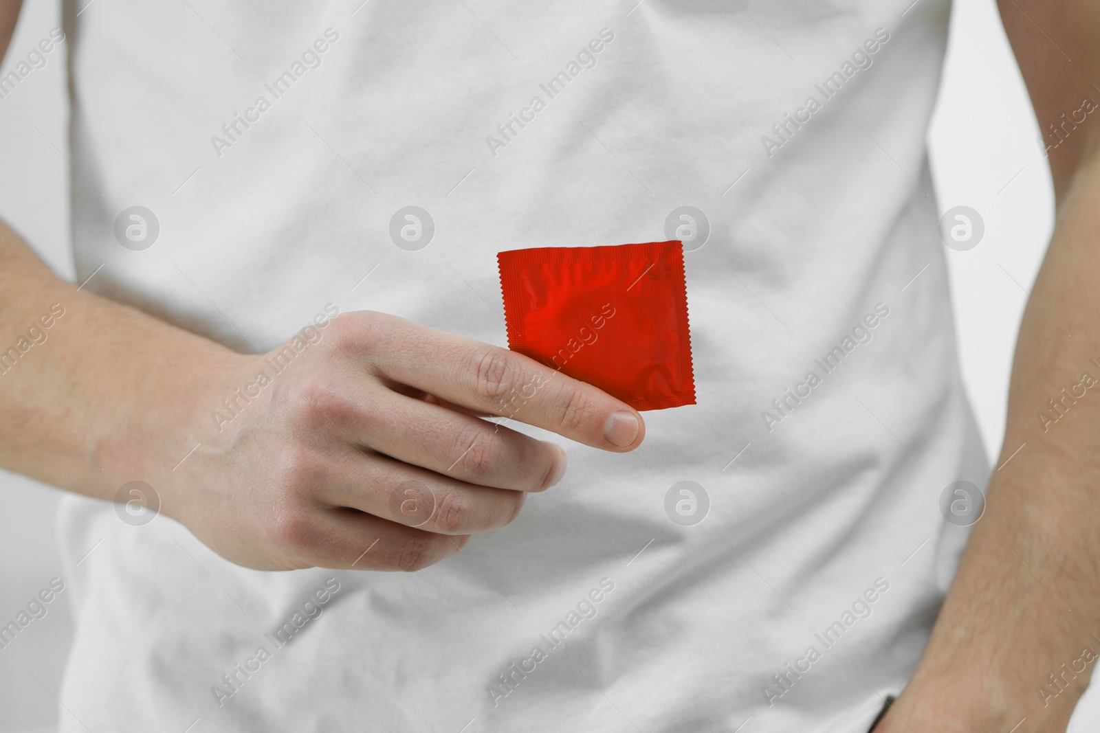 Photo of Man with pack of condom on white background, closeup