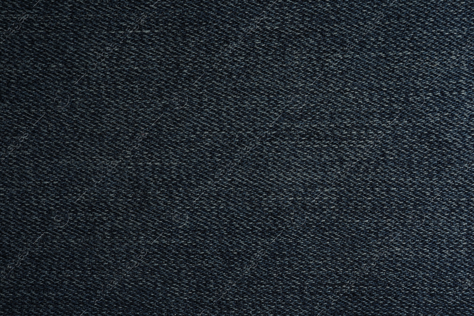 Photo of Texture of dark blue jeans as background, closeup