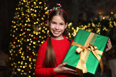 Photo of Portrait of happy child with Christmas gift at home