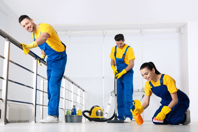 Photo of Team of professional janitors cleaning room after renovation