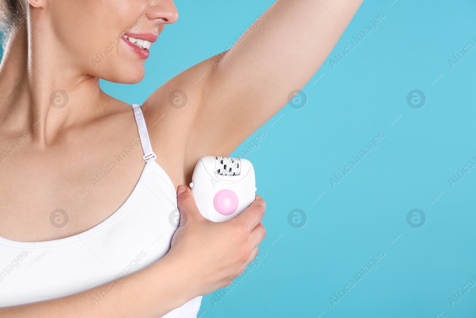 Photo of Woman doing armpit epilation procedure on blue background, closeup