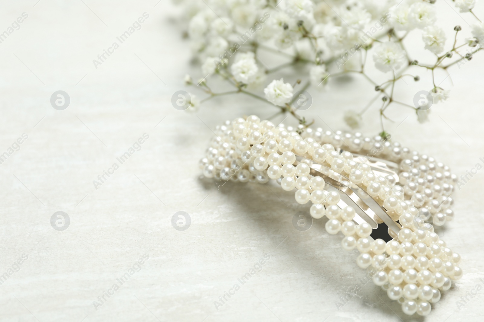 Photo of Beautiful hair clips and flowers on white table. Space for text