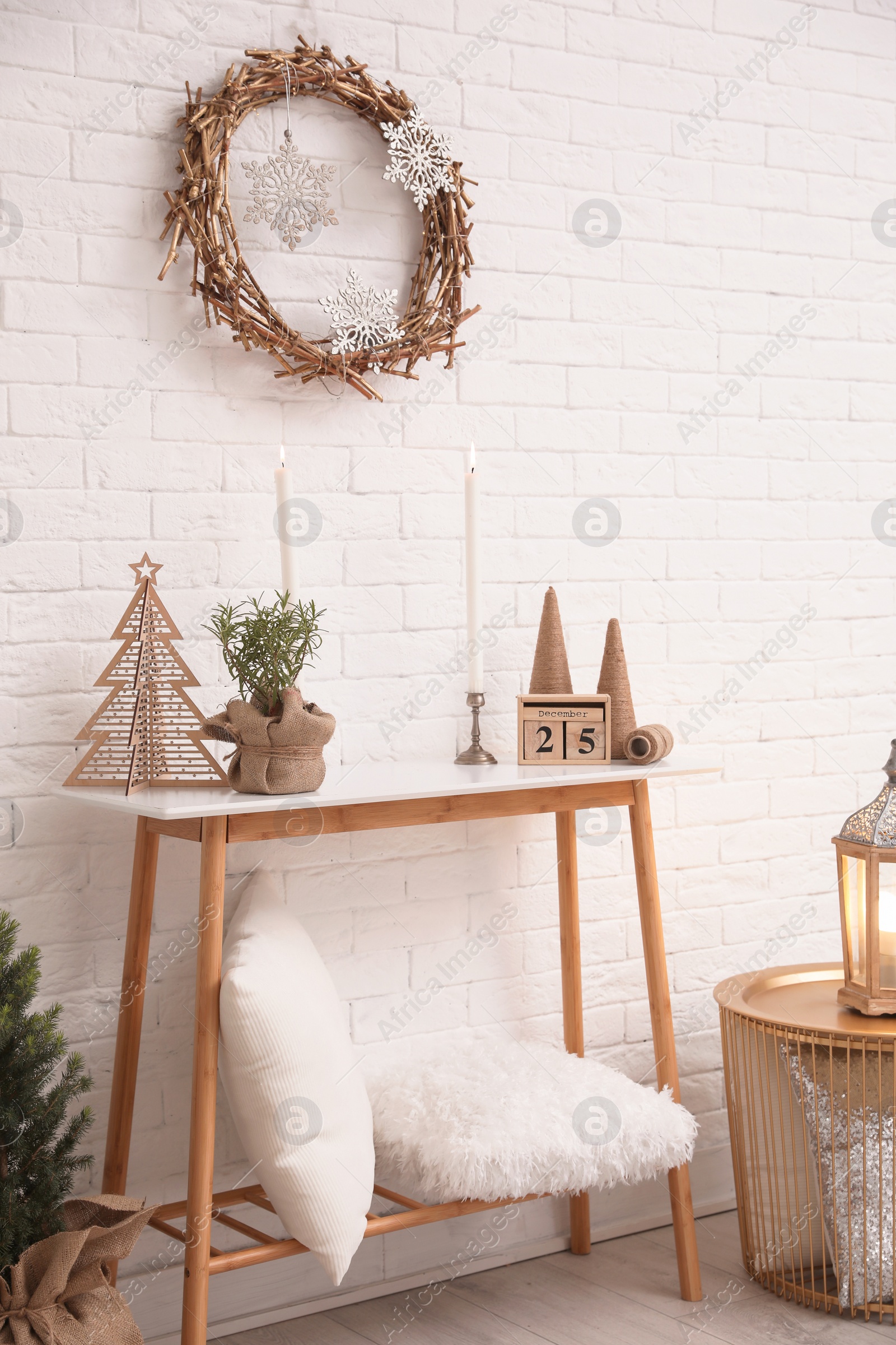 Photo of Console table with Christmas decoration near brick wall. Idea for festive interior