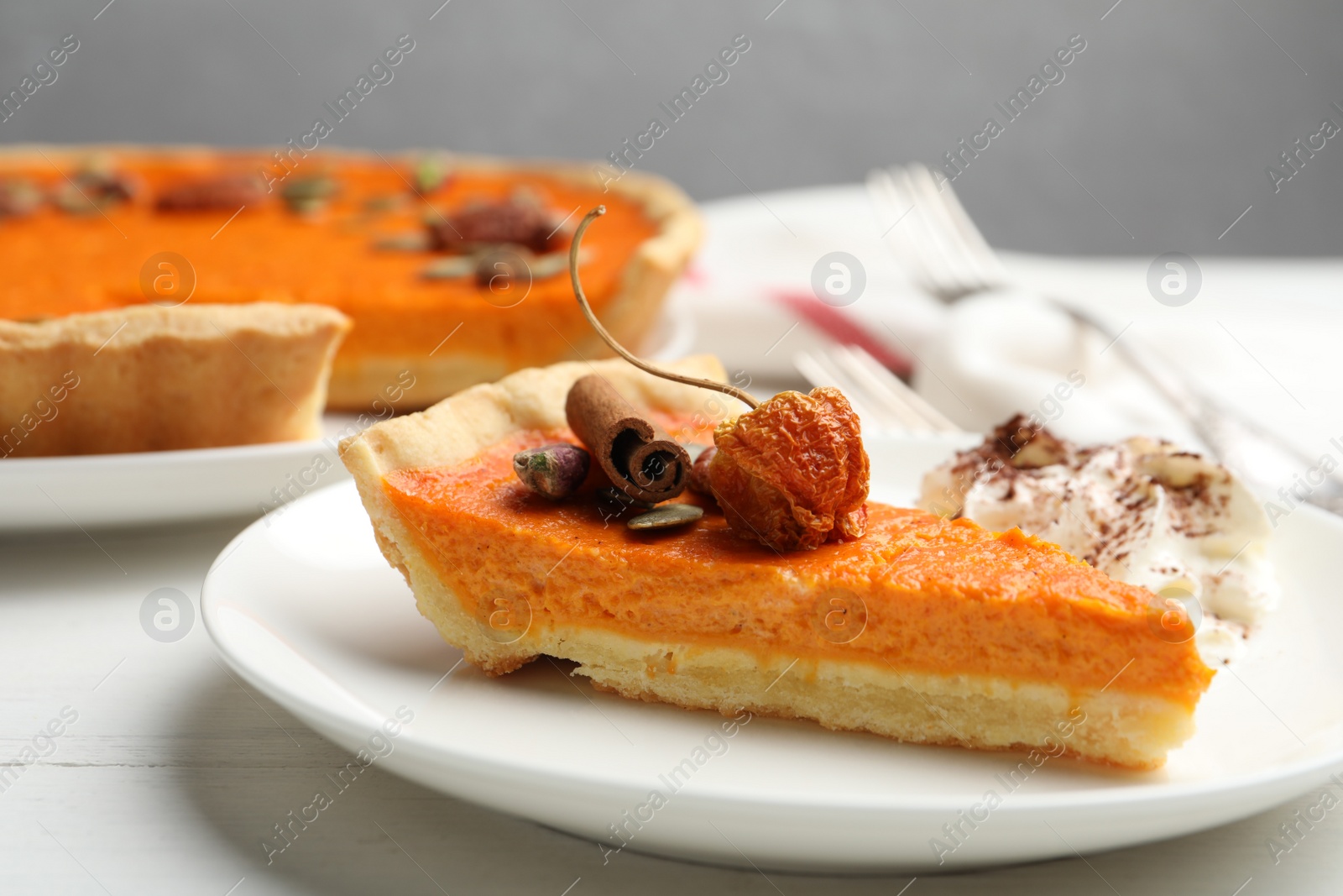 Photo of Slice of delicious homemade pumpkin pie on white wooden table, closeup