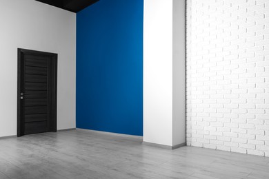 Photo of Empty renovated room with white walls and black door