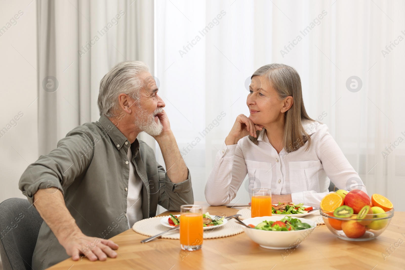 Photo of Happy senior couple having dinner at home