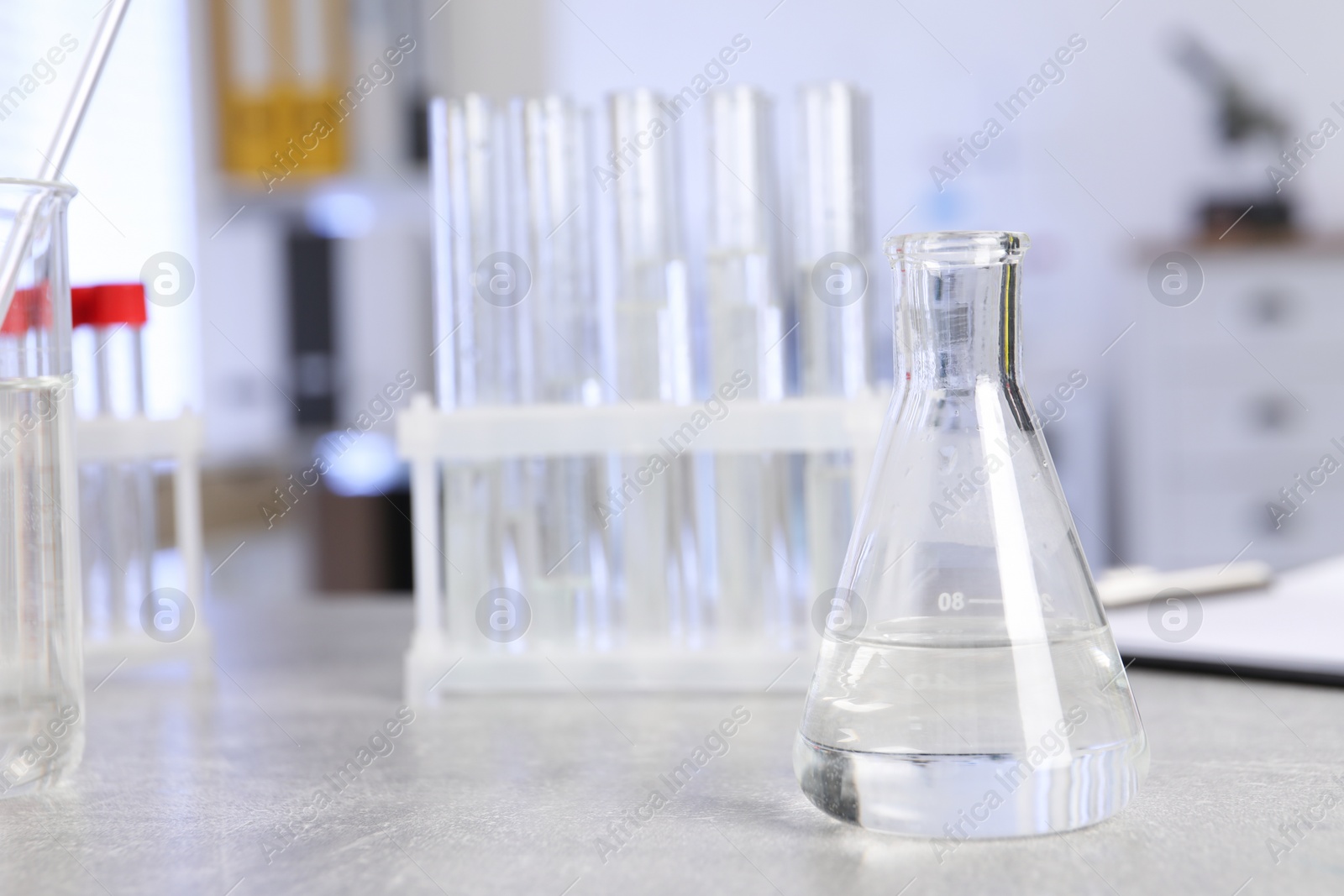 Photo of Laboratory analysis. Flask and test tubes on light grey table indoors