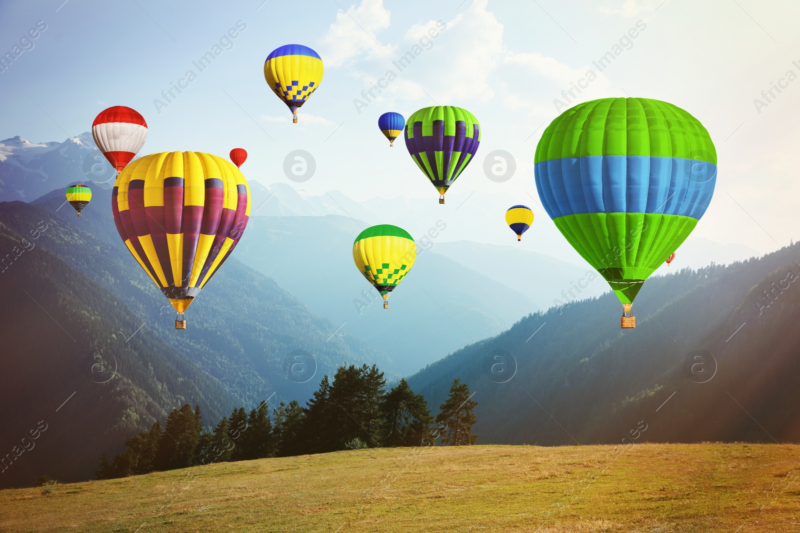 Image of Bright hot air balloons flying over mountains