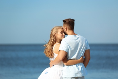 Happy young couple at beach on sunny day