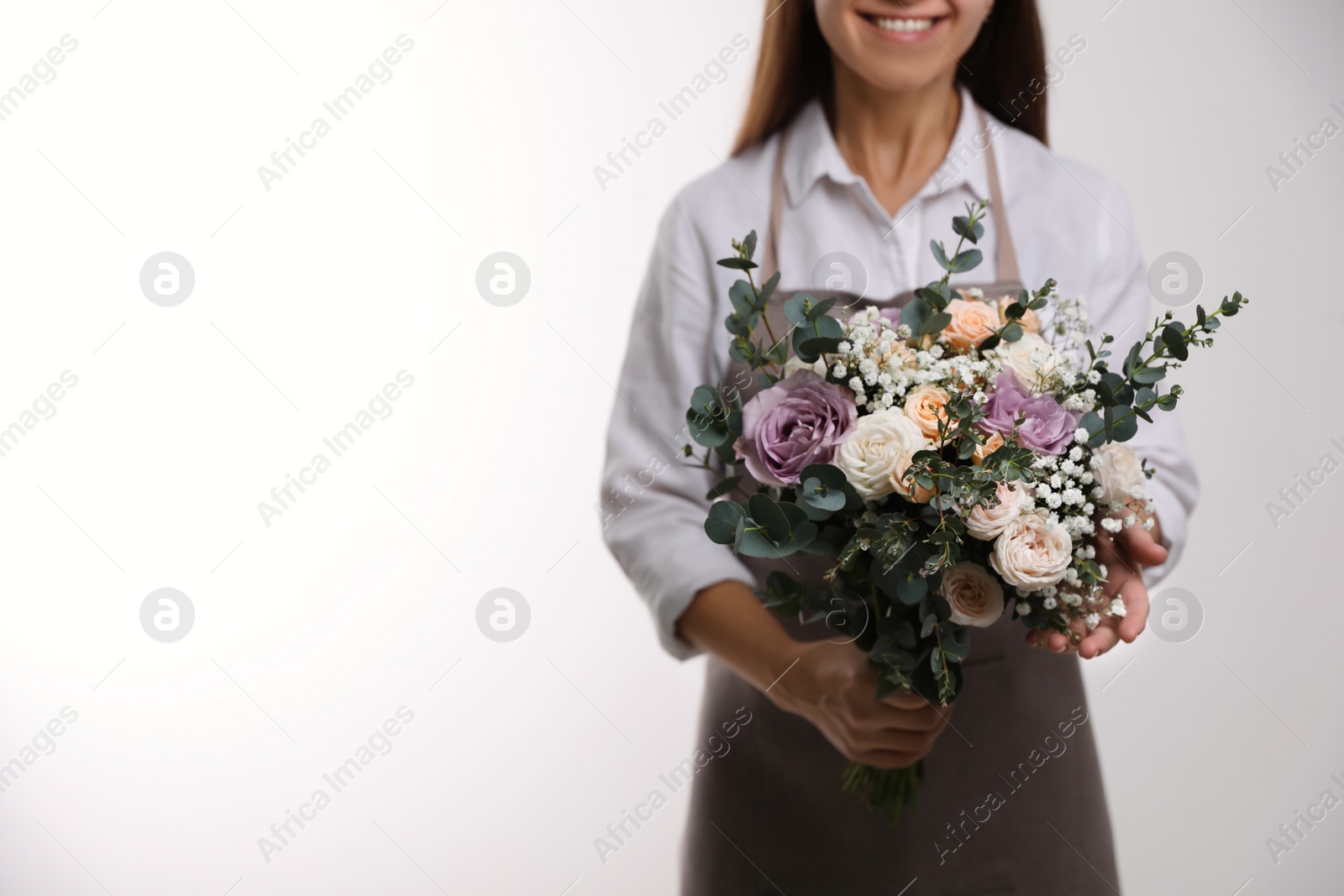 Photo of Florist holding beautiful wedding bouquet on white background, closeup