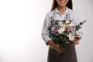 Photo of Florist holding beautiful wedding bouquet on white background, closeup