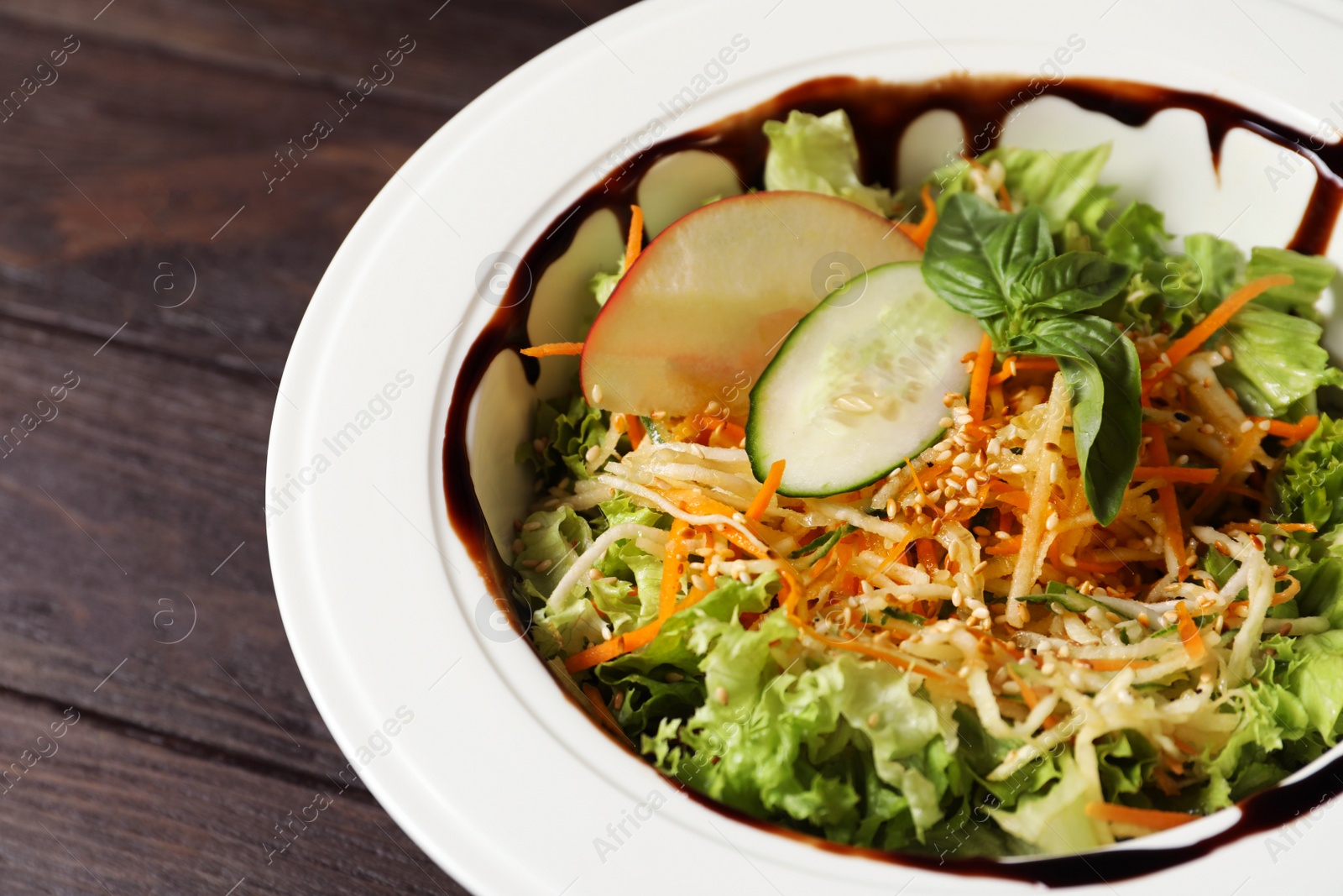 Photo of Plate with delicious fresh salad on table, closeup