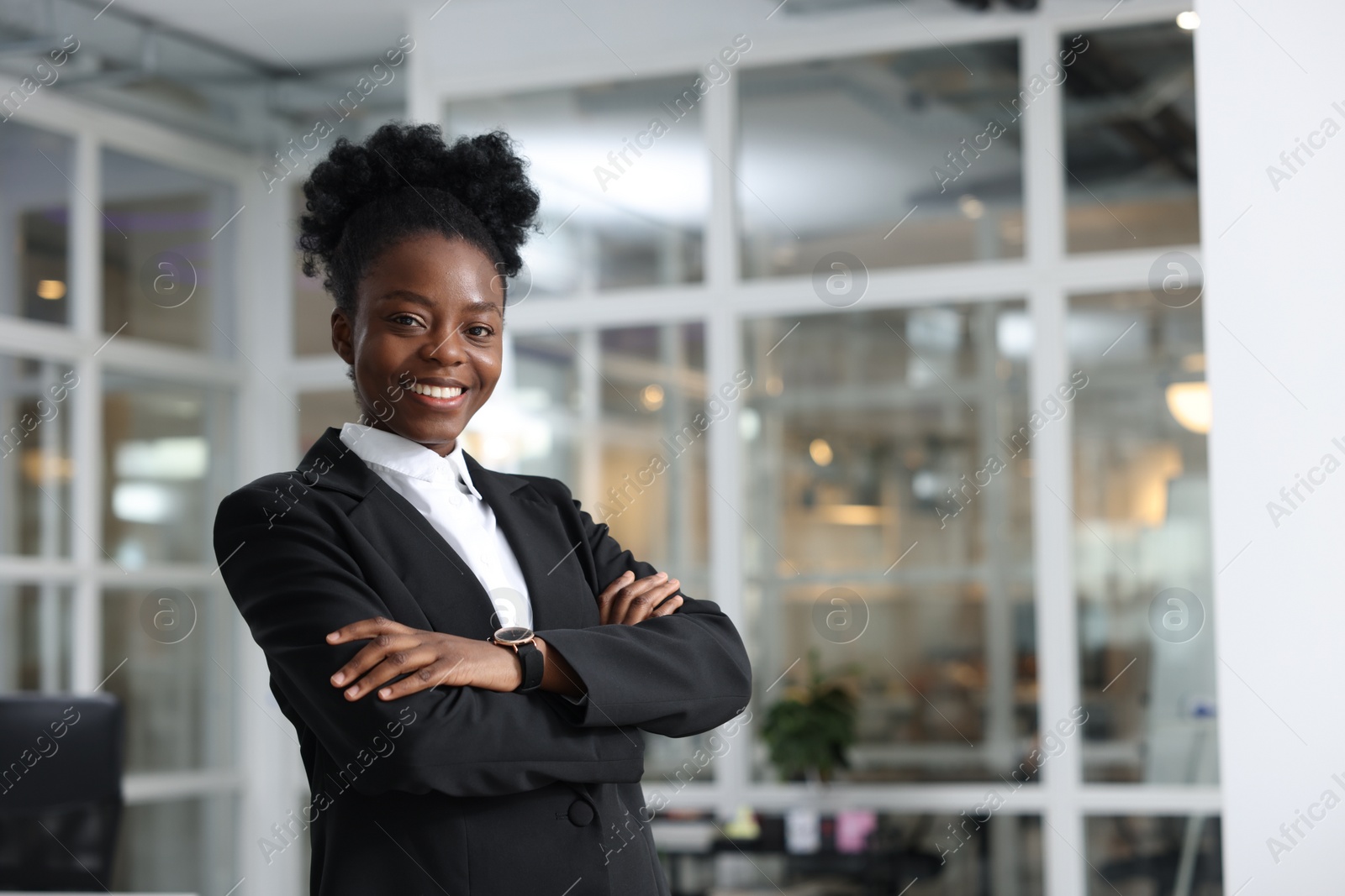 Photo of Happy woman with crossed arms in office, space for text. Lawyer, businesswoman, accountant or manager