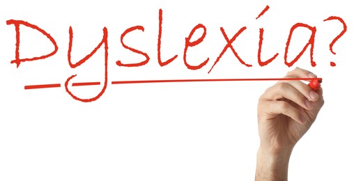 Man writing word Dyslexia on white background, closeup. Banner design