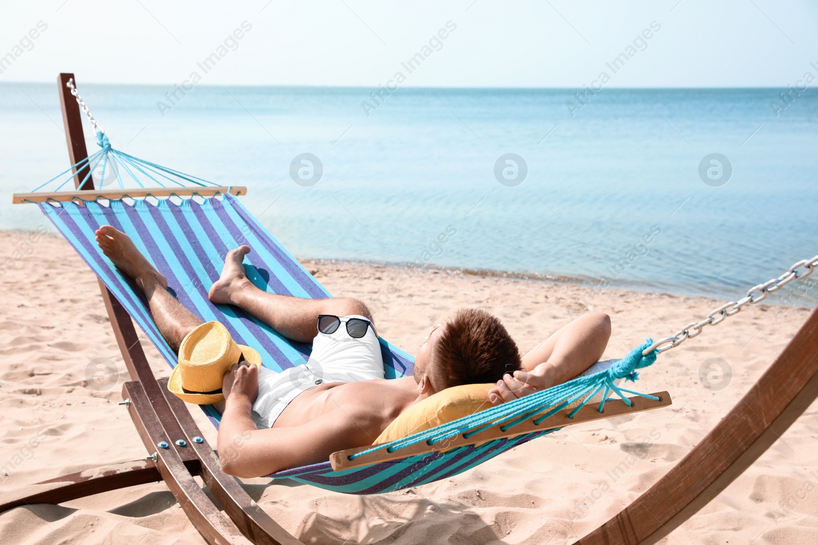 Photo of Young man relaxing in hammock on beach