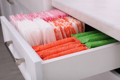 Photo of Storage of different feminine hygiene products in drawer indoors, closeup