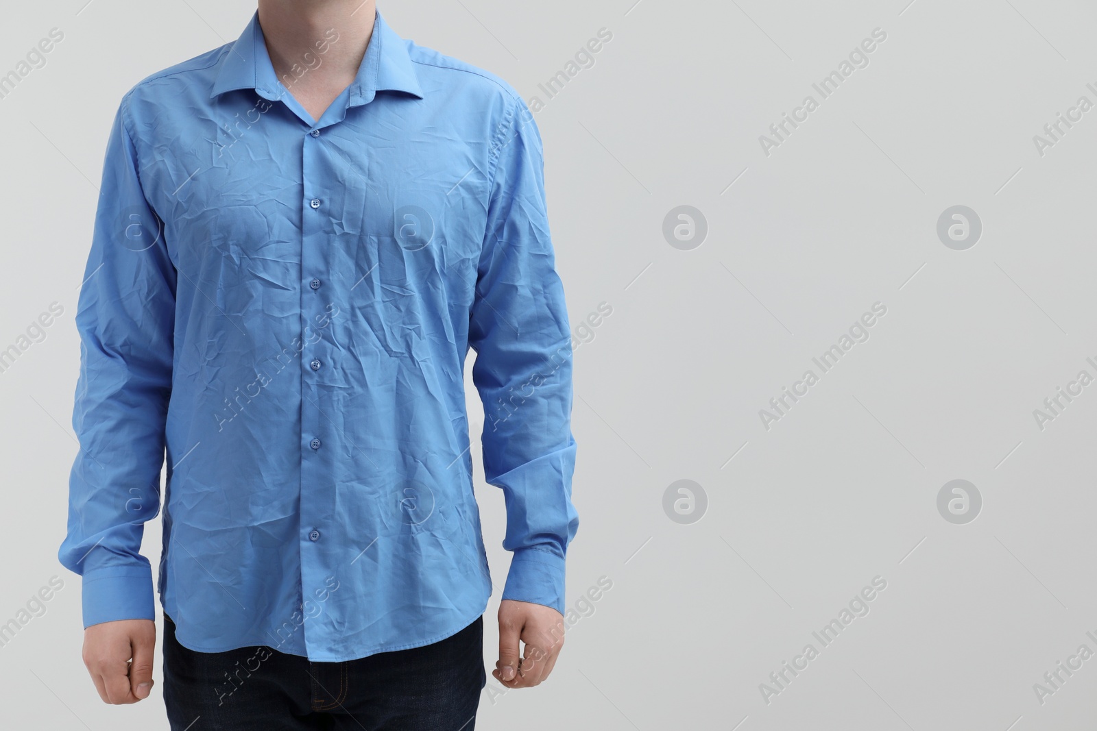 Photo of Man wearing creased shirt on light background, closeup. Space for text