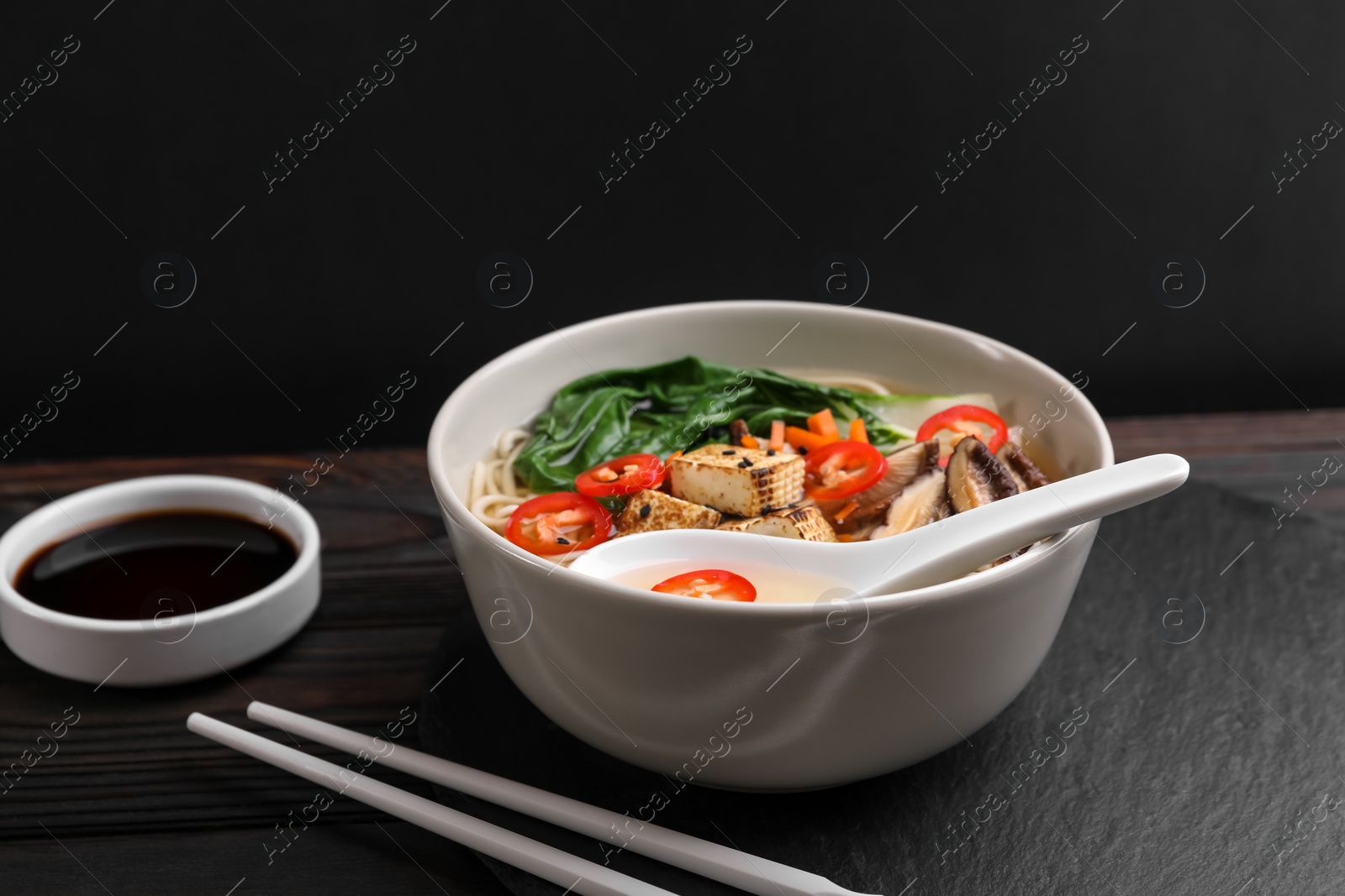 Photo of Bowl of vegetarian ramen served on dark wooden table