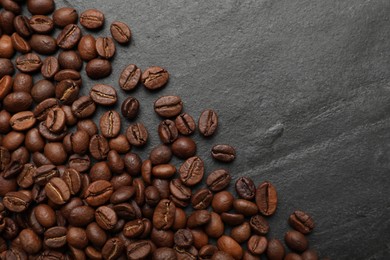 Photo of Aromatic coffee beans on black table, flat lay. Space for text