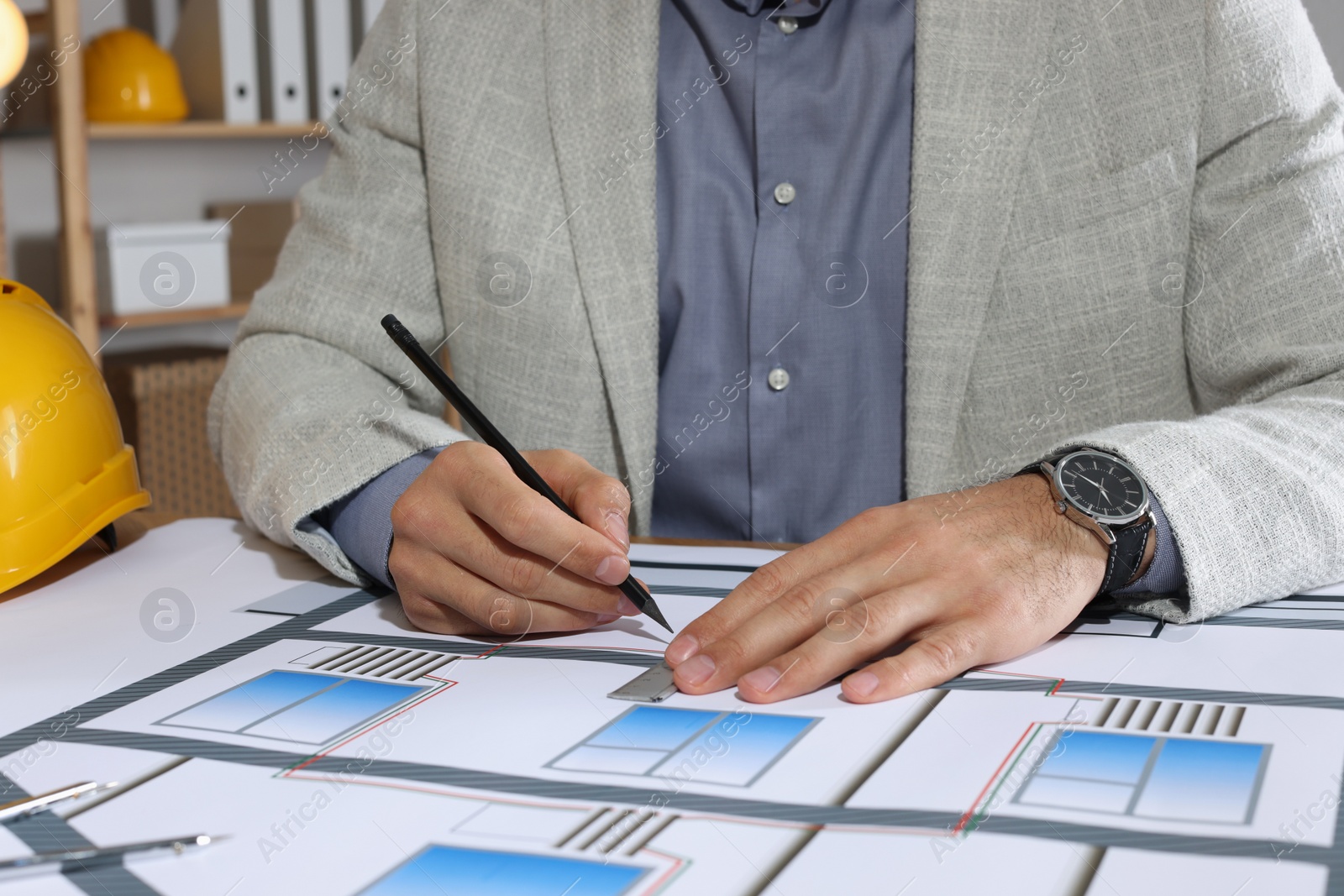 Photo of Architect working with construction drawings in office, closeup