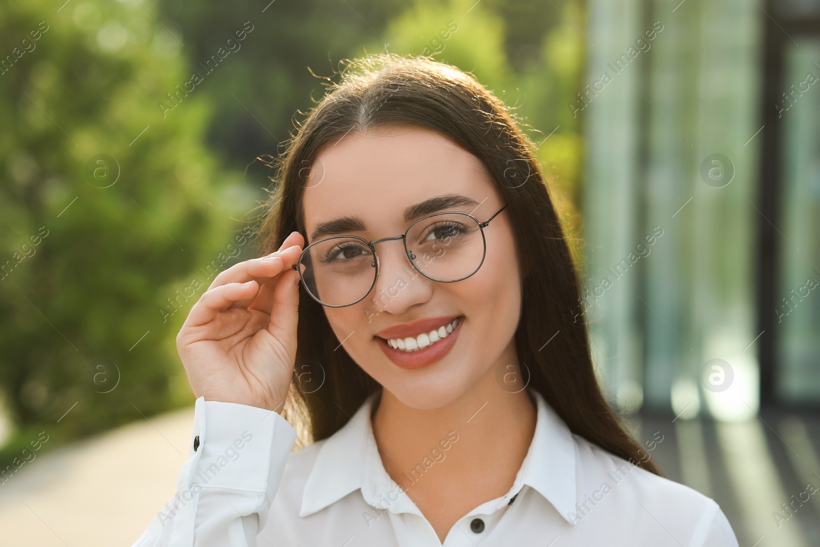 Photo of Portrait of beautiful woman in glasses outdoors. Attractive lady smiling and looking into camera