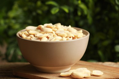 Photo of Fresh peanuts in bowl on table against blurred background