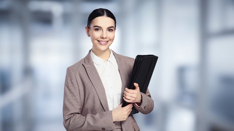 Image of Beautiful real estate agent with leather portfolio in office