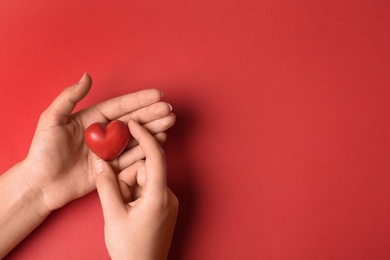 Photo of Woman holding decorative heart on red background, top view with space for text. Happy Valentine's Day