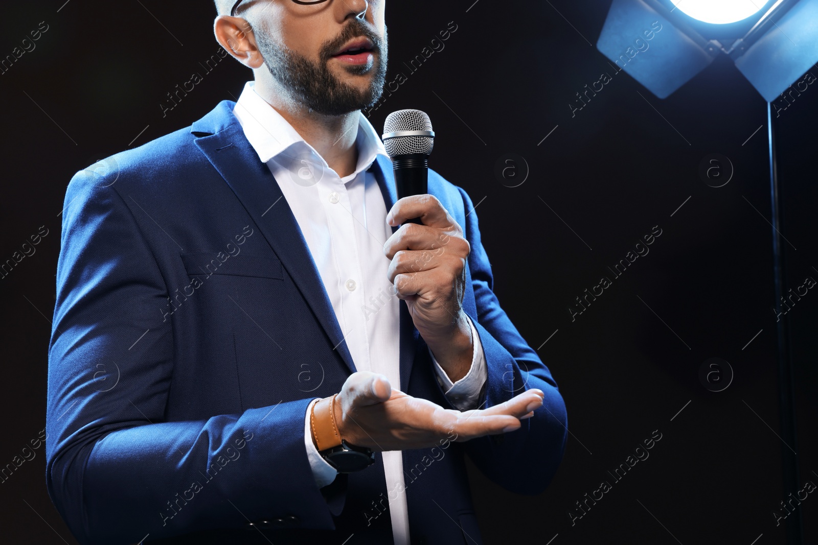 Photo of Motivational speaker with microphone performing on stage, closeup. Space for text