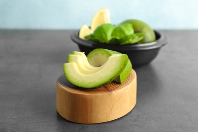 Wooden stump with cut avocado on table