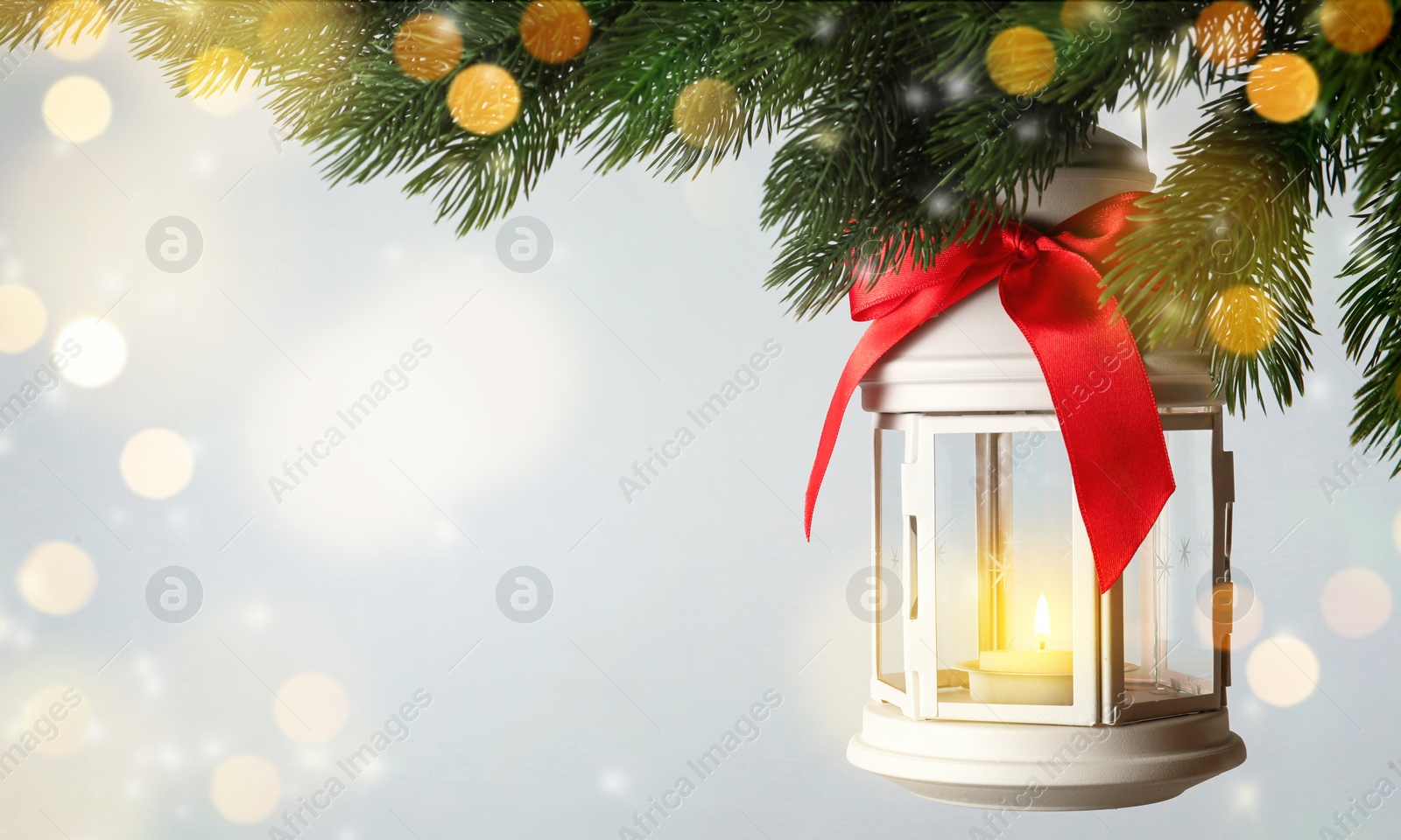 Image of Christmas lantern with candle hanging on fir tree branch against light background, space for text 