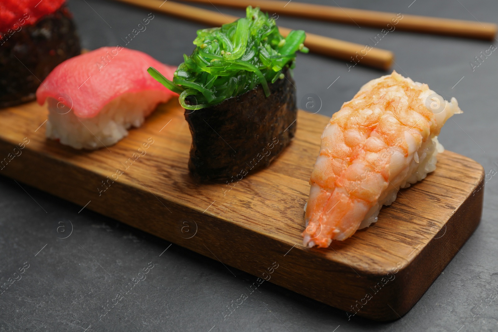 Photo of Set of delicious sushi on grey table, closeup