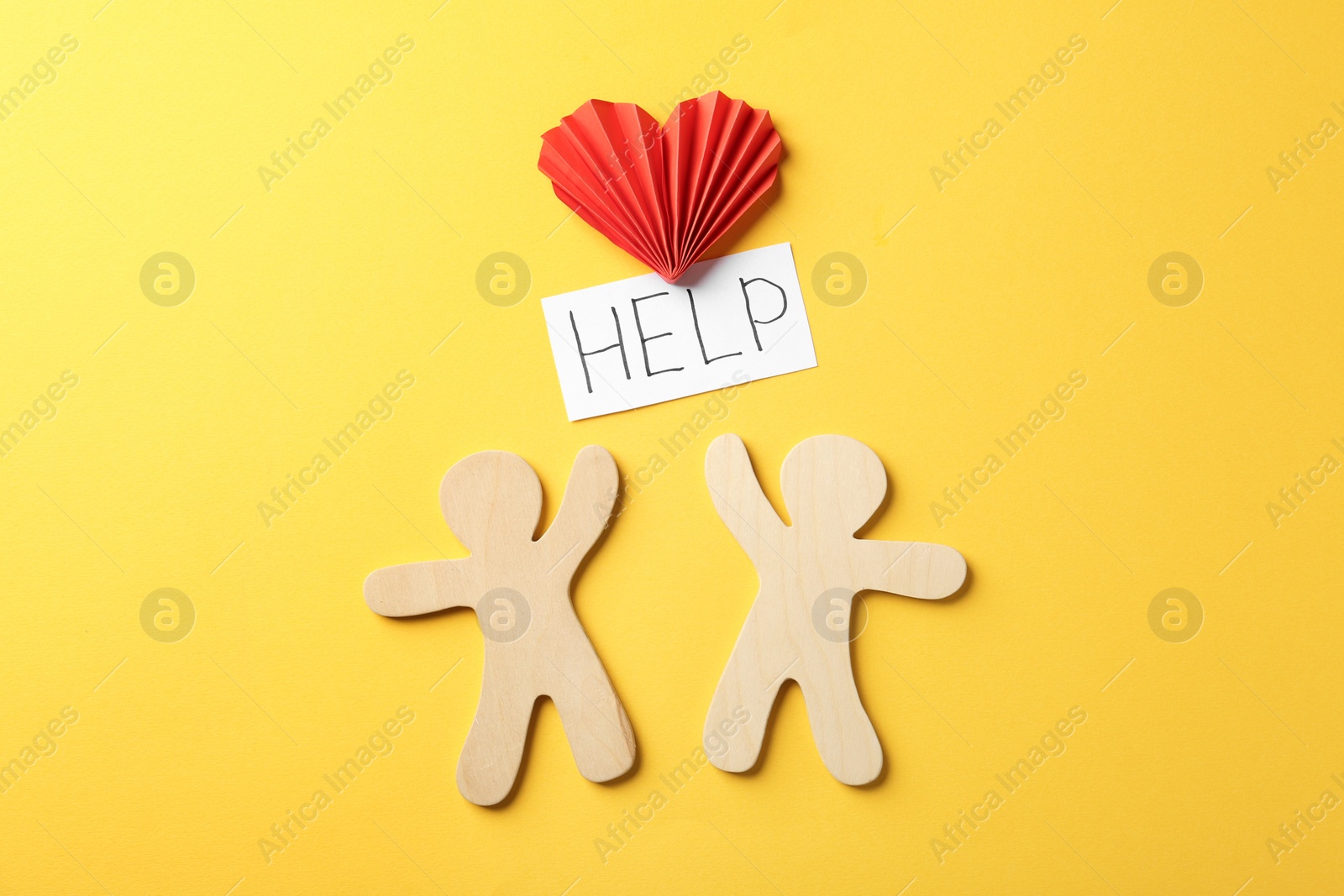 Photo of Flat lay composition with wooden people, paper heart and note HELP on color background