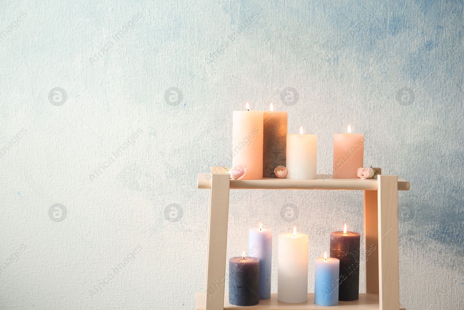 Photo of Shelving unit with decorative candles against color background