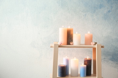 Photo of Shelving unit with decorative candles against color background