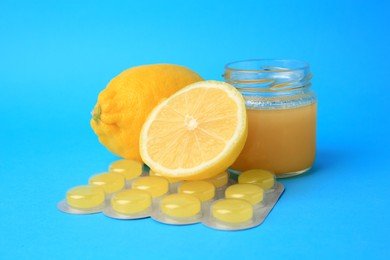 Photo of Blister with cough drops, fresh lemons and honey on light blue background