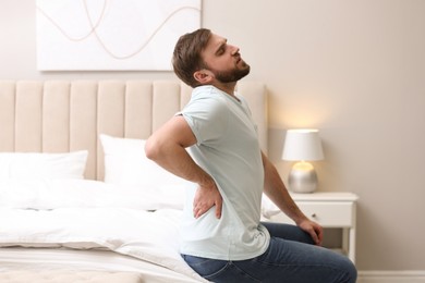 Man suffering from back pain at home. Bad posture problem