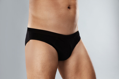 Man in black underwear on light grey background, closeup