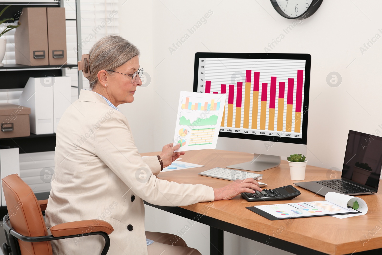 Photo of Senior accountant working at wooden desk in office