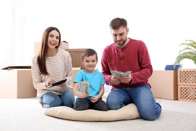 Happy family with money on floor at home