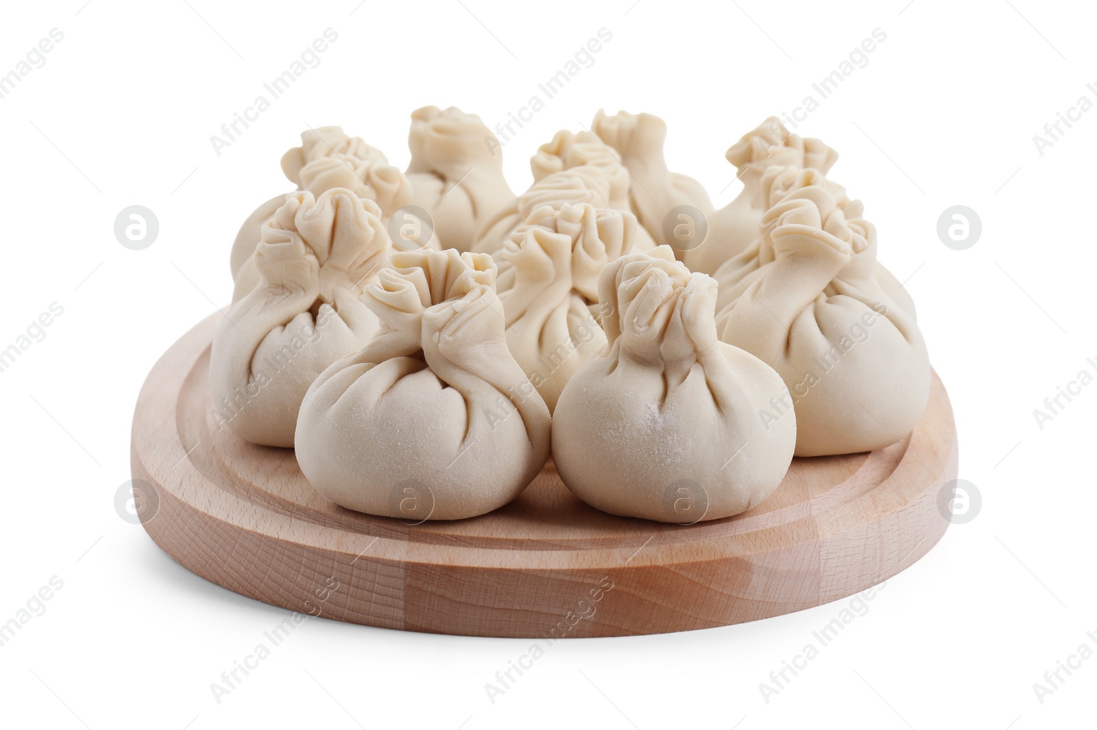 Photo of Wooden board with uncooked khinkali (dumplings) isolated on white. Georgian cuisine