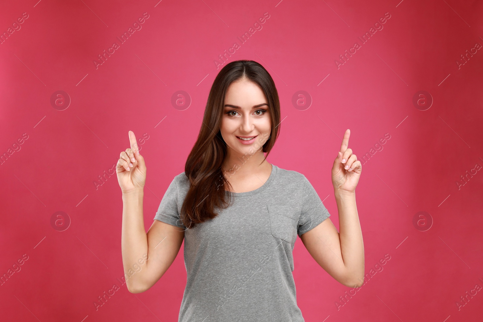 Photo of Beautiful young woman in casual outfit on crimson background