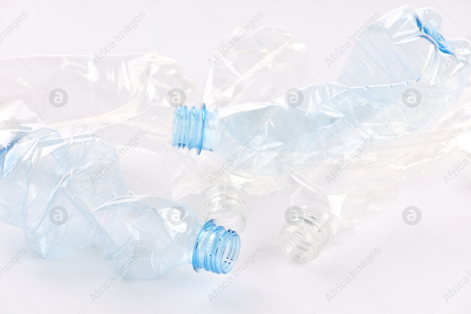 Photo of Crumpled disposable plastic bottles on white background