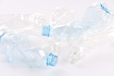 Photo of Crumpled disposable plastic bottles on white background