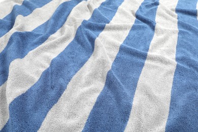 Photo of Crumpled striped beach towel as background, closeup view