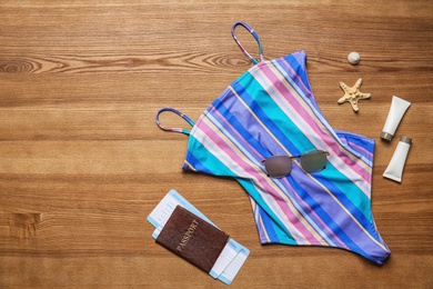 Flat lay composition with passport and beach objects on wooden background