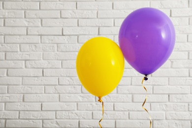 Photo of Bright balloons near brick wall, space for text. Celebration time