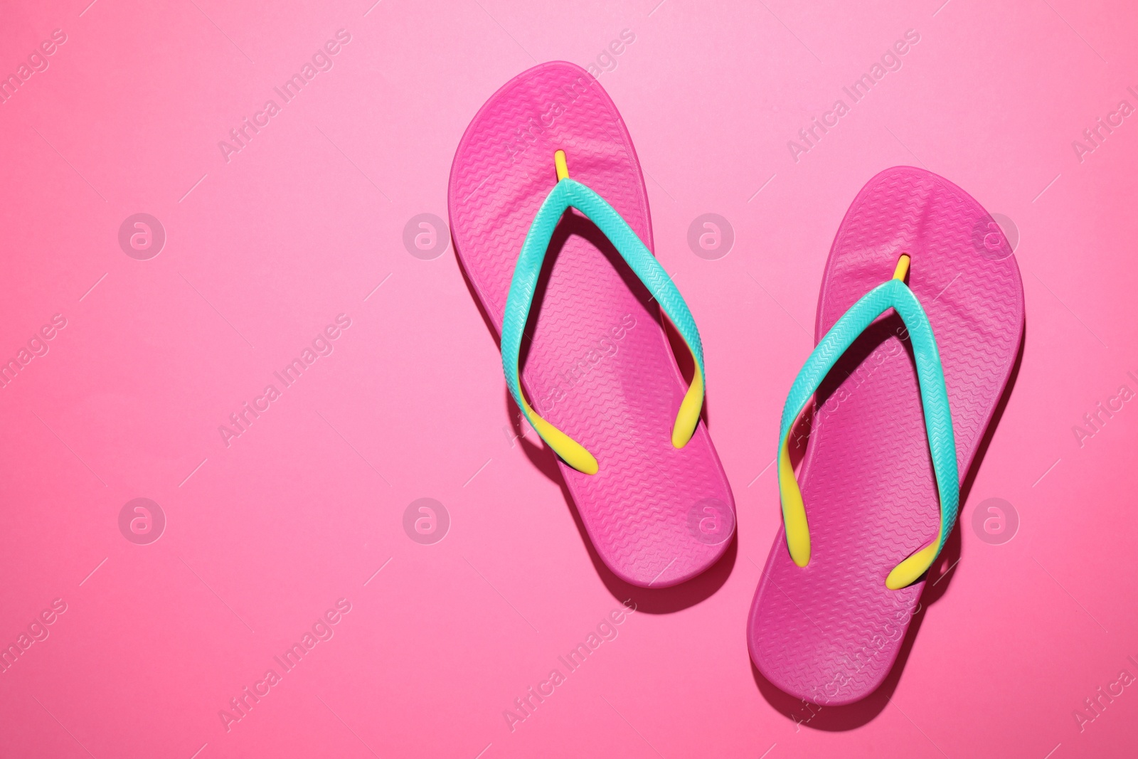 Photo of Pair of stylish flip flops on pink background, top view with space for text. Beach objects