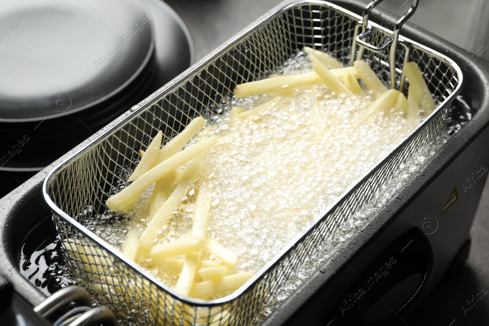 Photo of Cooking delicious french fries in hot oil